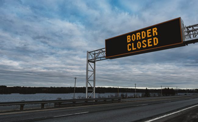 Border Closed Border closed displayed on overhead highway sign. Composite image.