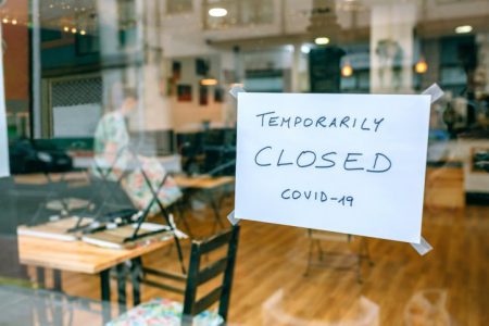 Coffee shop closed by covid-19 with workers picking up and cleaning inside